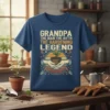 Grandpa The Man The Myth The Gardening Legend quote on a blue t-shirt, featuring gardening graphics and a plant