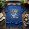 Blue t-shirt with "GRANT IFA GRANDMAS AGAINST FASCICM" text in distressed gold font, political statement design