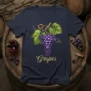 Navy t-shirt featuring a golden script text "Grapes" above a realistic illustration of a purple grape cluster with green leaves