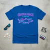 Grayton Beach Florida neon sign style text above a glowing shark graphic on a blue t-shirt