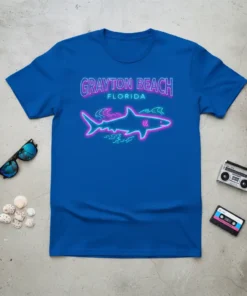 Grayton Beach Florida neon sign style text above a glowing shark graphic on a blue t-shirt
