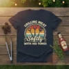 Grilling Meat Softly With His Tongs t-shirt featuring barbecue tools and a sunset graphic