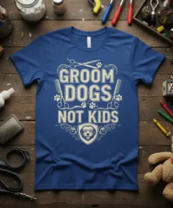 Groom Dogs Not Kids text design on a blue t-shirt with scissors, combs, and paw prints, featuring a dog's face