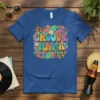 Groovy Mama text in colorful retro font with butterflies and psychedelic patterns, printed on a blue t-shirt