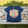 Groovy Mama text in a colorful retro font with floral mandala design on a navy t-shirt