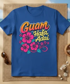 Guam Hafa Adai text with pink hibiscus flowers and tropical leaves on a blue t-shirt
