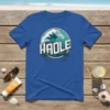 Blue t-shirt with "HADLE" text and a large ocean wave graphic, framed by rope and two palm trees