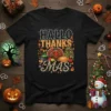 Hallo Thanks Mas text with a cartoon turkey, pie, and Christmas tree on a black t-shirt