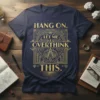 Navy blue t-shirt with gold text "Hang On. Let Me Overthink This." in a geometric design, featuring compass and gears