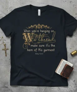 Black t-shirt with gold text quote "When you're hanging on by a thread make sure it's the hem of His