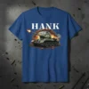 HANK text above a green tank breaking through a brick wall, firing its cannon, on a blue t-shirt