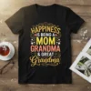 Happiness is Being a Mom Grandma & Great Grandma quote on a black t-shirt with colorful typography and floral accents