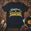Happiness is Dancing quote on a black t-shirt with stylized text and a smiling curve graphic