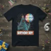 Happy Birthday Birthday Boy Godzilla T-Shirt design featuring a green kaiju holding a rainbow balloon and wearing a cake hat