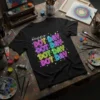 Black t-shirt with "Happy DOT DAY DOT DAY DOT DAY DOT DAY DOT DAY" text in neon-like colors and scattered