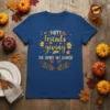Happy Friendsgiving The Family We Choose text with autumn leaves and floral wreath graphic on a blue t-shirt