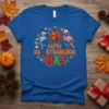 Happy Hallothanksmas Mas t-shirt with skeleton, turkey, and flamingo characters in a festive circle design