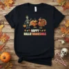 Happy Hallothanksmas text with skeleton and turkeys graphic on a black t-shirt, perfect for holiday mashup celebrations
