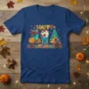Happy Hallowthanksmas text with Halloween pumpkins, spooky drinks, and Christmas tree graphic on a blue t-shirt