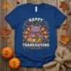 Happy Thanksgiving text with a cartoon hippo wearing a pilgrim hat and eating turkey on a blue t-shirt