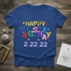 Happy Tuesday 2.22.22 text design with colorful gem letters and heart accents on a blue t-shirt