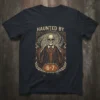 Haunted By 6-7 T-Shirt with a skeleton wearing a suit and holding its head, surrounded by swirling patterns and laurels