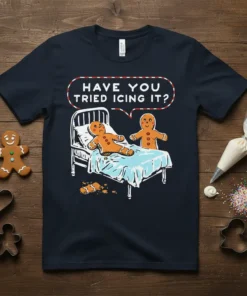 Gingerbread man in bed asking "Have You Tried Icing It?" on a navy t-shirt, humorous holiday design