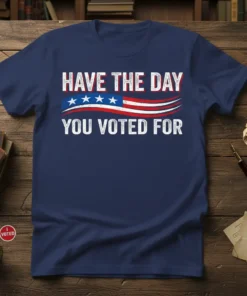 Navy blue t-shirt with bold white text "HAVE THE DAY YOU VOTED FOR" above an American flag graphic