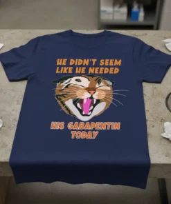 He Didn't Seem Like He Needed His Gabapentin Today cat t-shirt design with orange text and a laughing cat graphic