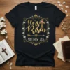 He is Risen Matthew 28:6 Christian T-Shirt with gold glitter lettering and a floral cross graphic