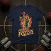 HE IS Rizzin basketball player dunking graphic on a navy t-shirt, number 23 visible, bold yellow and orange text