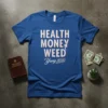 Blue t-shirt with "HEALTH MONEY WEED Yang 2020" text in distressed white and red font, featuring a silhouette of a