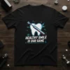 Healthy Smile Is Our Game text with a tooth and electric toothbrush graphic on a black t-shirt