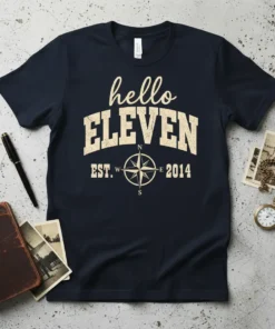 Navy blue t-shirt with "hello ELEVEN EST. 2014" in distressed cream font and a compass graphic