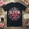 Black t-shirt with "hello ELEVEN EST. 2015" in pink floral design, featuring a bow and wreath