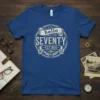 Blue t-shirt with "hello SEVENTY EST. 1955" vintage design in cream text and graphics