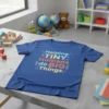 Helping TINY Humans do BIG Things quote on a blue t-shirt, featuring colorful typography and decorative elements