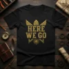 Black t-shirt with distressed gold text "HERE WE GO" and a compass graphic, ideal for adventure seekers