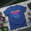 Blue t-shirt with "Hey Dude" text and a silhouette of a surfer on a retro grid wave, featuring vibrant sunset