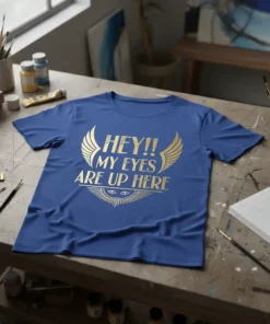 HEY!! MY EYES ARE UP HERE text with golden wings and eye graphic on a blue t-shirt
