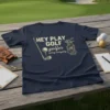 Navy t-shirt with "HEY PLAY GOLF golfer swing everyday" text, golf club, ball, and golf bag graphic