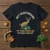 Deer standing on vegetables with text "Hey Vegetarians My Food Poops On Your Food!" on a black t-shirt