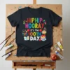 Hip Hip Hooray It's The 100th Day T-Shirt with colorful text, apples, books, and art supplies