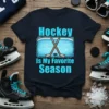 Hockey Is My Favorite Season quote with ice rink graphic and crossed sticks on a navy t-shirt