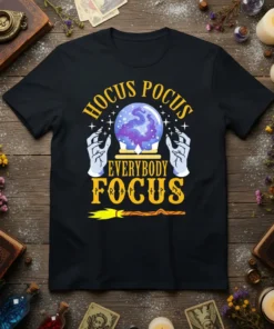 Hocus Pocus Everybody Focus text with crystal ball and witch hands graphic on a black t-shirt