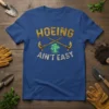 Hoeing Ain't Easy quote t-shirt with gardening tools and a plant graphic