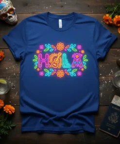 Blue t-shirt with a neon sign graphic spelling "HOLA" surrounded by colorful flowers and leaves, featuring a guitar illustration