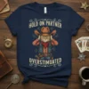 Navy t-shirt with "Hold On Partner Overstimulated" text above a cat dressed as a cowboy, hands on its head