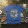 Homeless Lives Matter text with floral wreath graphic on a royal blue t-shirt