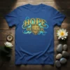 Gold foil text "HOPE DEALER" in vintage font with glowing blue and yellow swirls on a royal blue t-shirt